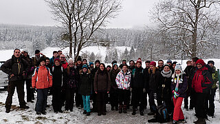 Group of people standing in a snowy landscape.