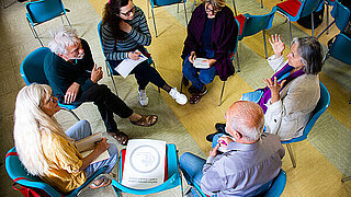 Workshop participants sit in a circle and discuss