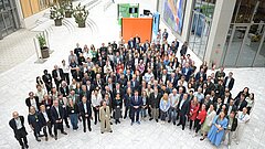 Gruppenfoto mit etwa 200 Personen und Bundesumweltminister Carsten Schneider