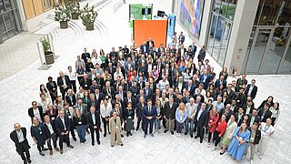 Gruppenfoto mit etwa 200 Personen und Bundesumweltminister Carsten Schneider