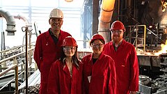 Johannes Kuron, CEO der Beinbauer Group und KEI Mitarbeitende bei der Werksführung vor dem Kupolofen aus dem flüssiges Eisen fließt.