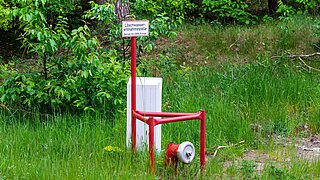 Bick auf eine Löschwasserentnahmestelle, im Hintergrund Bäume