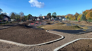 Blick auf eine künstlich angelegte Fläche mit kleinen Erhebungen und mit Steinen eingefaßten Bereichen