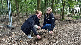 Zwei Frauen hocken sitzen auf den Paludi-Matten und schauen in die Kamera
