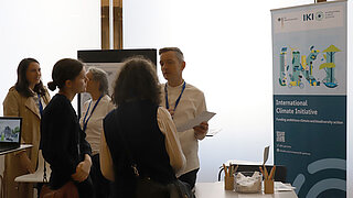 Menschen stehen an einem Stand der Internationalen Klimaschutzinitiative