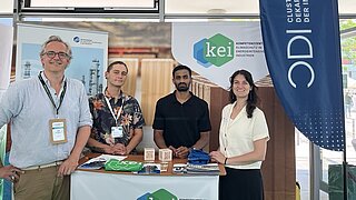 Foto von vier Personen am Stand des KEI bei den Decarbon Days 2026