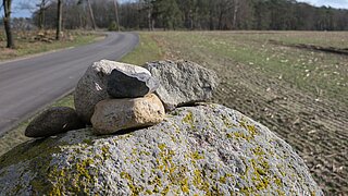 Steine vor einem Radweg in ländlicher Umgebung