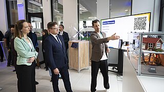 Bundesumweltminister Carsten Schneider und Constanze Haug stehen vor einem Monitor auf dem eine Präsenation abgebildet ist