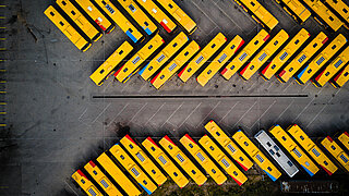 Aerial view of a bus station: many yellow buses parked in a row