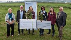 Sechs Personen zeigen symbolische Förderschecks