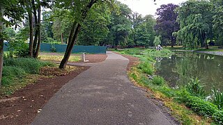 Asphaltierter Weg am Ufer eines Teichs