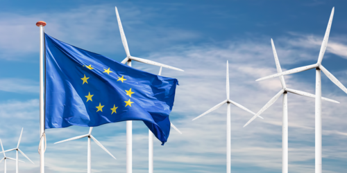 Vor einigen Windrädern weht eine EU-Fahne