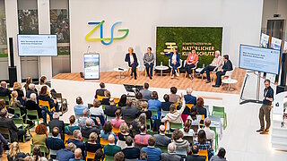 Publikum und Podium bei der KNK-Eröffnungsfeier