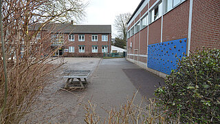 Asphaltierter Schulhof und Gebäude der Theodor-Fliedner-Schule in Meerbusch