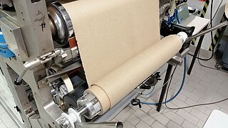 Eine Maschine rollt eine Papierrolle aus Paludimaterialien auf.