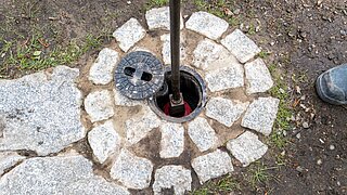 Geöffneter Schacht mit Schieber zur Wasserstandsregulierung der neuen Dükerleitung. Die technische Anlage ermöglicht die kontrollierte Zuführung von Wasser aus der Havel in das Moorgebiet.