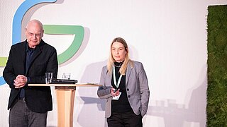 Eine Mann und eine Frau stehen an einem Stehtisch