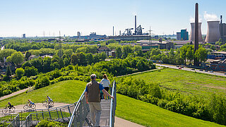 Panoramasicht auf ein Industriegebiet mit Radfahrenden und Fußgänger*innen