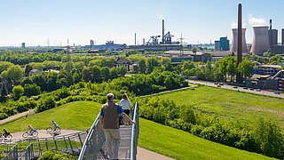Panoramasicht auf ein Industriegebiet mit Radfahrenden und Fußgänger*innen
