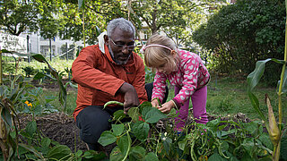Älterer Mann mit Kind im Garten