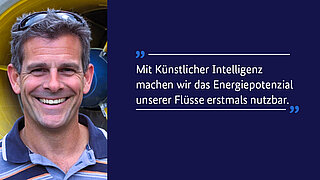 Porträt eines lächelnden Mannes mit kurzen grauen Haaren und Sonnenbrille auf dem Kopf, der vor einer gelben technischen Anlage steht, die an eine Turbine oder Energieinfrastruktur erinnert. Rechts daneben auf dunkelblauem Hintergrund steht ein Zitat in weisser Schrift: „Mit Künstlicher Intelligenz machen wir das Energiepotenzial unserer Flüsse erstmals nutzbar.“