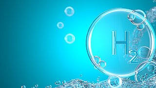 Mehere Gasblasen vor hellblauem Hintergrund. Eine Gasblase ist mit "H2" beschriftet.