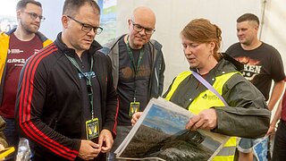 5 Personen schauen gemeinsam Bilder an. 