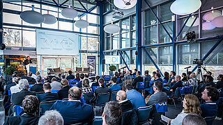 Publikum hört einem Speaker zu.