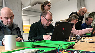 Workshopteilnehmende arbeiten vor Laptops
