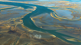 Landschaft mit Wiesen und Wasser im Hamburger Wattenmeer von oben.