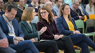 Zwei Personen unterhalten sich (sie sitzen im Publikum)