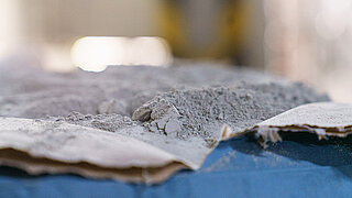 Unverarbeiteter Zement sickert aus einer Papierpackung.