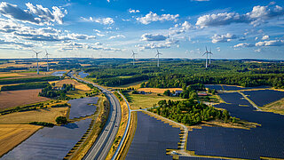 Solarpark und Windkraftanlagen in der Nähe der Autobahnkreuzung