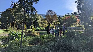 Eine Gruppe von Kindern mit Erzieher*innen im Garten des Umweltbildungszentrums