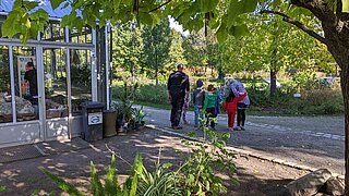 Eine kleine Gruppe von Kindern und Erzieher*innen vor dem Grünen Klassenzimmer