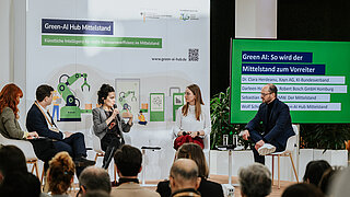 Menschen auf Podium zu KI für Ressourceneffizienz im Mittelstand