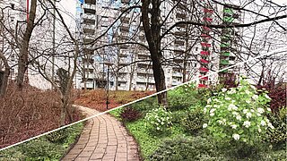 Geteilter Vergleich einer Böschung mit gepflastertem Weg, links kahl und braun, rechts grün mit blühenden Sträuchern und Bäumen.