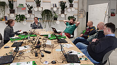 Workshopteilnehmende vor einer Pflanzenwand