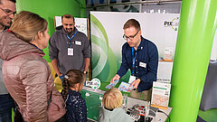 Ein Mann verteilt Geschenke an Kinder während der Nacht der klugen Köpfe.