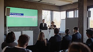 ein Podium mit 2 Personen und einem Bildschirm 