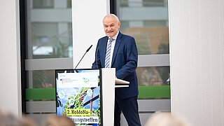 Ein Mann (ZUG-Geschäftsführer Stefan Demuth) steht an einem Redepult und spricht. 