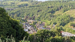 Ein Ort in einem Tal, auf den Bergen stehen Bäume 