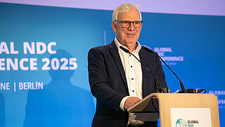 Ein Mann steht vor einem Rednerpult 
