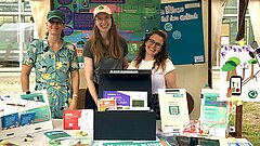 Infostand mit drei Frauen, die die KI-Box Klima vorstellen