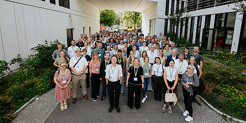Eine Menschengruppe posiert vor einem Gebäude (Gruppenbild) 