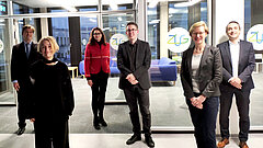 Menschen stehen vor einem Konferenzraum