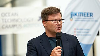 Ein Mann (Umweltminister Carsten Schneider) spricht in ein Mikrofon