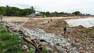 Ein Strand mit Plastikmüll bedeckt.